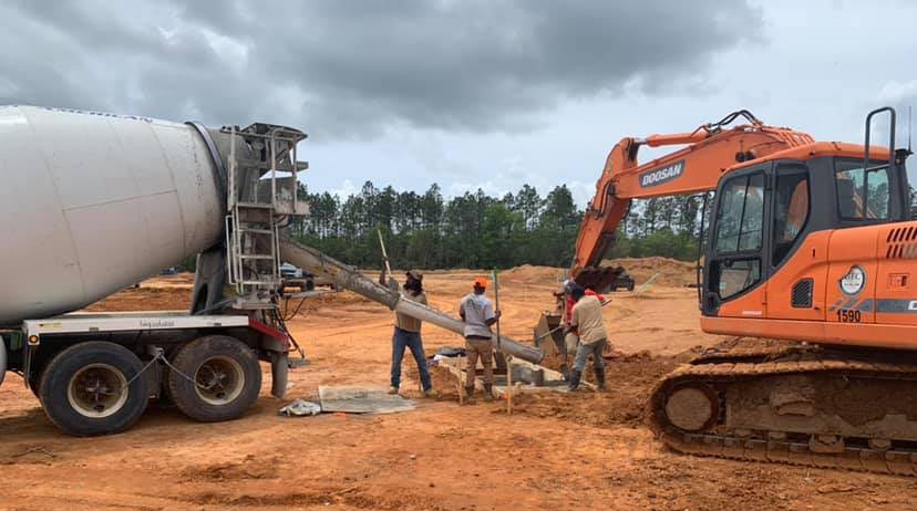 Workers pouring concrete for flatwork for a stormwater remediation project